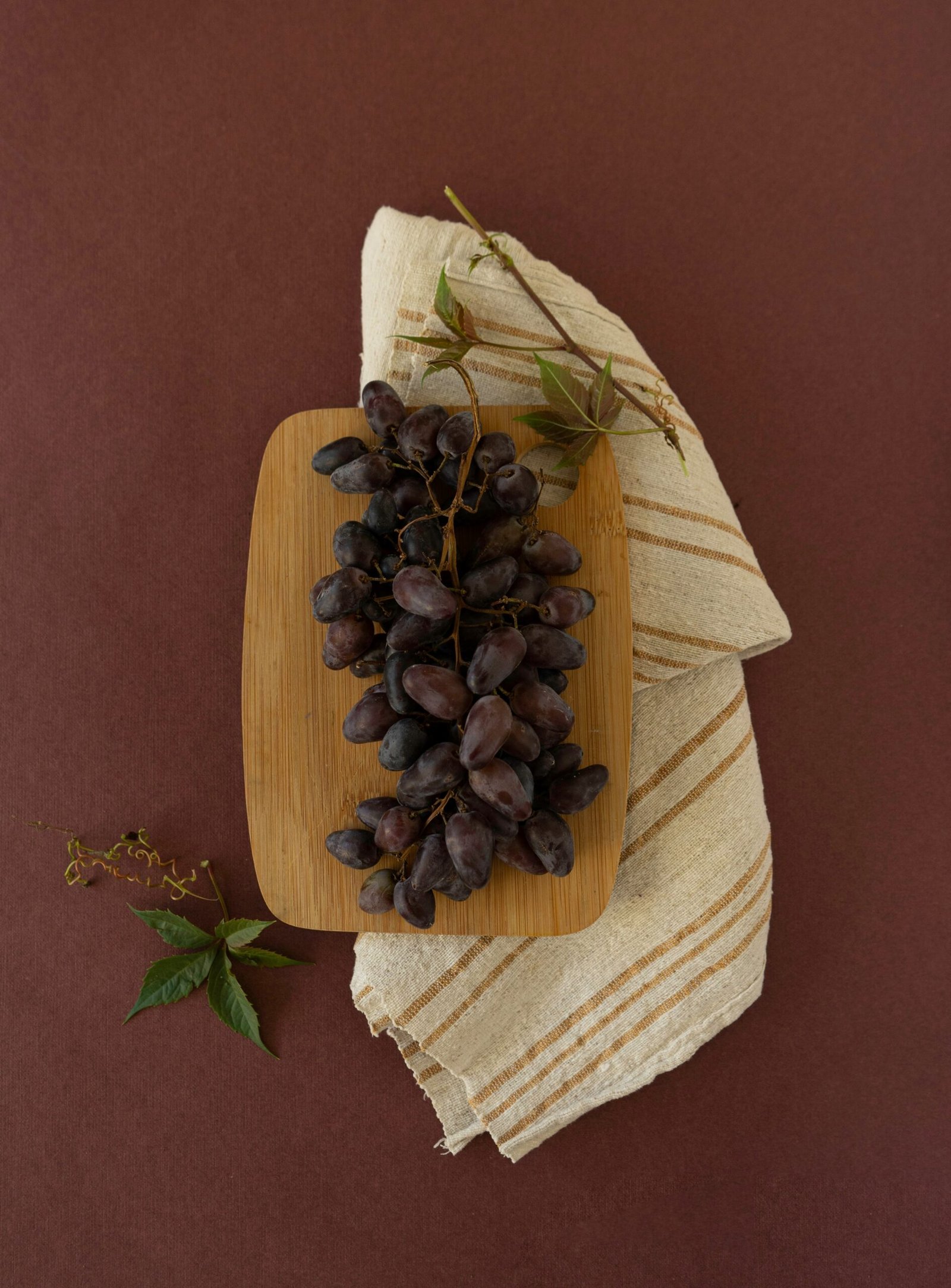 a bunch of grapes sitting on top of a wooden cutting board